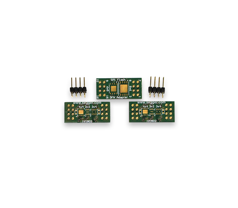SEGGER (Q)SPI Flash Evaluator Adapter board Pack for SON/DFN Image features three green circuit boards with gold contact pads, labeled for various functions, including one labeled "SPI Flash." Additionally, there are several connecting pins on the side. These are components typically used in electronics for circuit connections and programming.