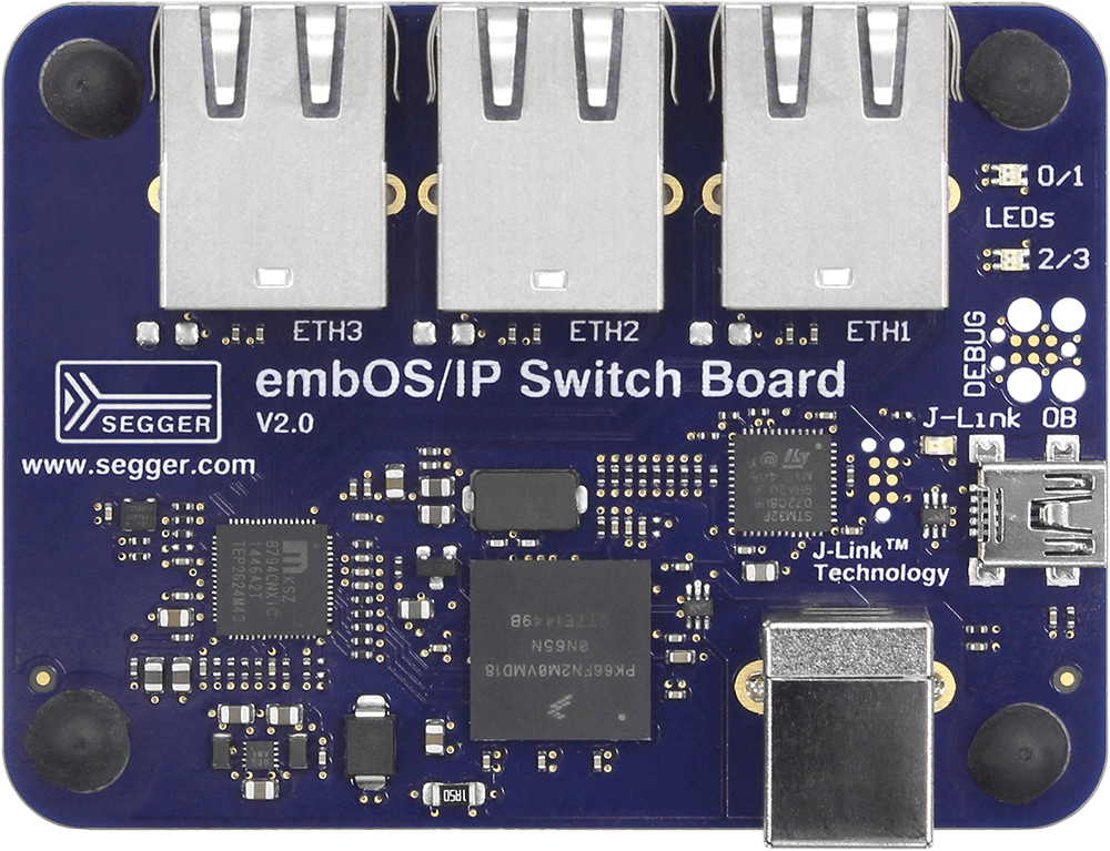 embOS/IP Switch Board Image of a blue circuit board labeled "embOS/IP Switch Board V2.0" by SEGGER. It features four Ethernet ports (ETH1, ETH2, ETH3), various electronic components, small LED indicators, and a USB connection marked "J-Link." The board is designed for networking applications.